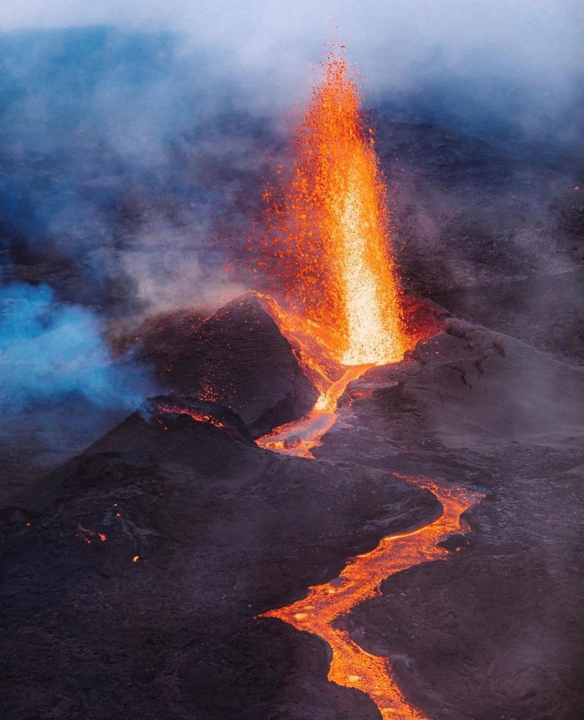 Photographed here is one of the three emission vents from Piton de la Fournaise's latest eruption. A steep-sided cinder cone has begun to build around the vent as a moderate lava fountain erupts into the air.