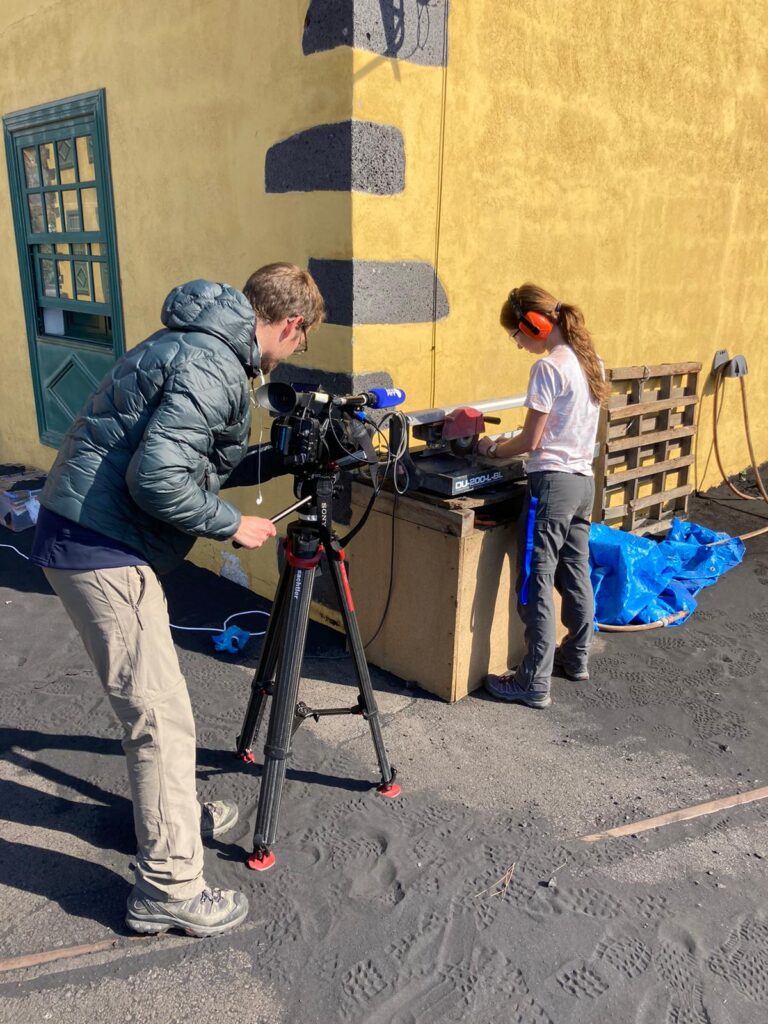 An image of Olivia cutting rock samples whilst being filmed and interviewed by Agence France-Presse.