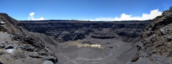 A panoramic image of Karthala volcano crater, showing a grey, desolate landscape.